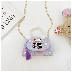 Détail de la broderie panda sur sac à fleurs avec poignée en perles et pompon