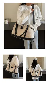 Detailed view of cream canvas travel tote with black leather trim and detachable shoulder strap