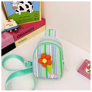 Detail of colorful striped crossbody bag with fabric flower and LOVE bead charm