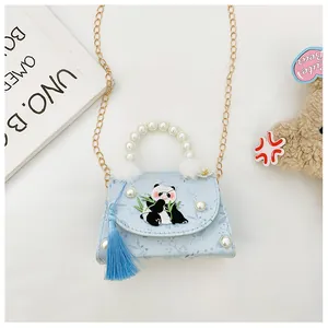 Détail de la broderie panda et de la poignée en perles sur le sac bleu pour enfants