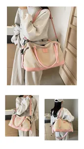 Detail of large canvas travel tote with pink leather handles and adjustable shoulder strap