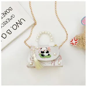 Détail de broderie panda sur un mini sac à main blanc avec poignée en perles et frange