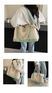 Close-up of a large beige canvas travel bag with green straps and adjustable shoulder belt