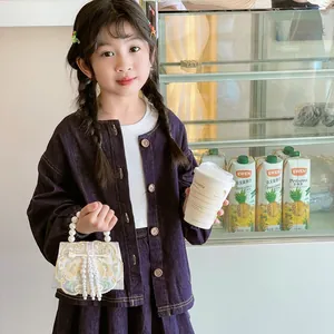 Girl's vintage embroidered handbag with pearl fringe and handle in a lifestyle setting