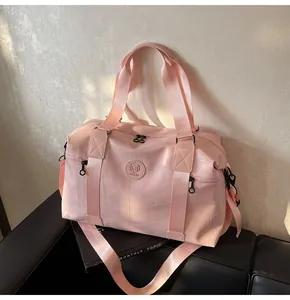 Detail der rosafarbenen Reisetasche aus Kunstleder mit Steppmuster und rundem Logo