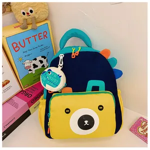 Close-up of colorful dinosaur kids backpack featuring bear pattern and a round coin pouch