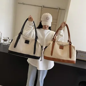 Close-up of contrast canvas and leather travel tote bag with large storage capacity