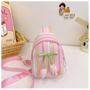 Detail of tulip crossbody bag featuring pink stripes and decorative floral pendants