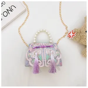 Detail of embroidered floral pattern on purple Chinese style bag with pearl handle