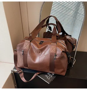 Nahaufnahme der braunen Reisetasche aus Leder mit NING JIA Logo und Schultergurt