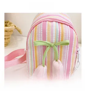 Detail of pink tulip charm and ribbon on striped sweet crossbody bag for girls