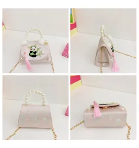 Vues détaillées du sac panda avec poignée en perles et détails de pompons roses
