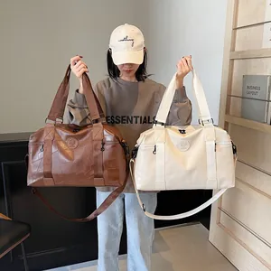 Detailansicht großer Reisetaschen in Dunkelbraun und Beige mit geometrischer Lederstruktur