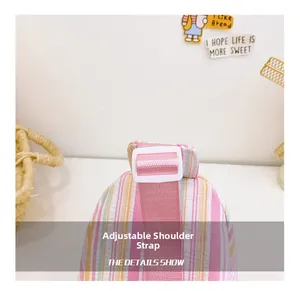 Detail of multi-color striped fabric chest bag with adjustable pink shoulder strap
