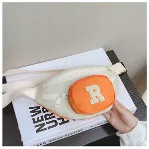 Detail of crossbody waist bag with chenille letter R patch and dual zipper pockets