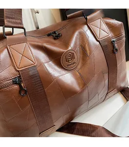 Detailaufnahme der braunen Reisetasche aus Kunstleder mit geometrischem Muster und Logo