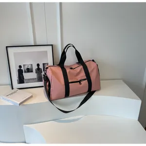 Detailed view of pink fitness bag with shoe compartment on a minimalist display stand