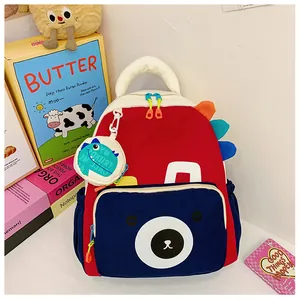 Close-up of kids dinosaur backpack featuring a bear print and colorful side fin details