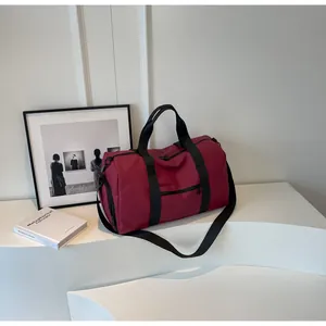 Macro shot of dark red travel duffel bag showing durable nylon fabric and zipper details