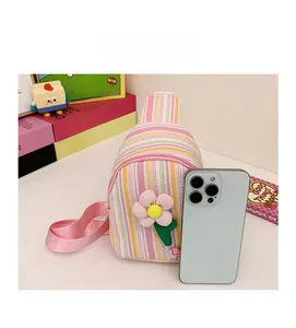 Detail view of small striped floral crossbody bag showing size comparison with a phone