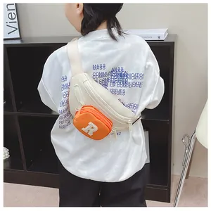 Detailed view of kids' waist bag with orange zip pocket and R letter embroidery