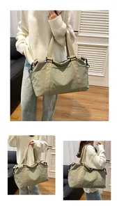 Dettaglio borsa da viaggio in nylon verde con ricamo MOPPO e robusti manici in tessuto beige