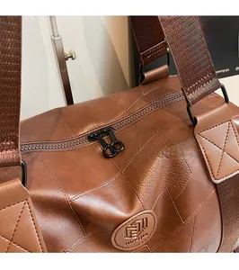 Nahaufnahme der hochwertigen Doppel-Metallreißverschlüsse an brauner Vintage-Reisetasche