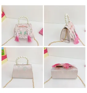 Detail of pink Chinese style mini bag with floral embroidery and pearl handle