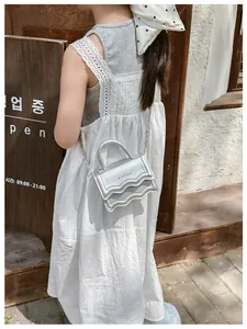 Détail du mini sac argenté métallisé avec bords ondulés et bandoulière en chaîne