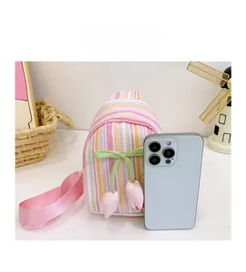 Mini pink striped girls crossbody bag size comparison with a white smartphone