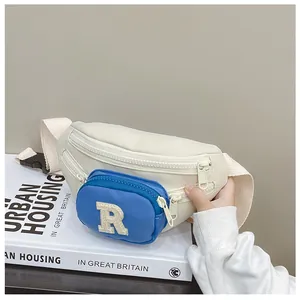 Detail of color-block kids chest bag with blue zipper pocket and towel-embroidered R letter