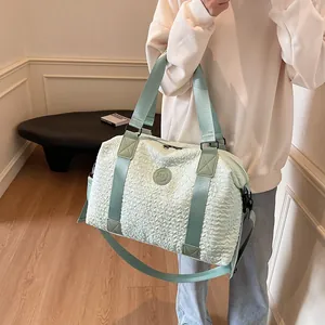 Detail of mint green large travel bag with bubble textured fabric and adjustable strap