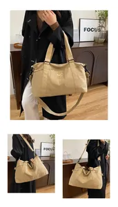 Dettaglio della borsa da viaggio beige capiente con logo e tracolla rimovibile