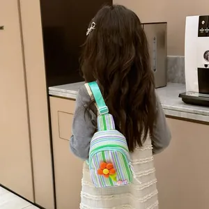 Kids colorful striped canvas crossbody bag with orange flower applique shown on model