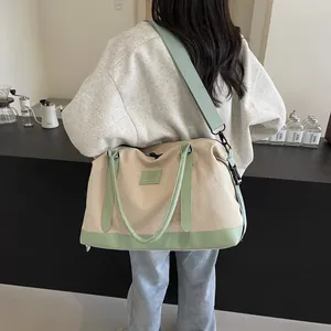 Detail of canvas travel bag with green faux leather trim and adjustable shoulder strap