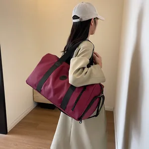 Detail of burgundy large capacity travel bag with waterproof nylon and black straps