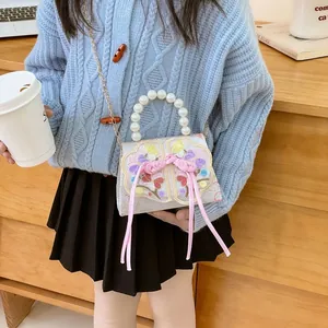 Girls ivory crossbody bag with floral embroidery, pearl handle and pink ribbon detail