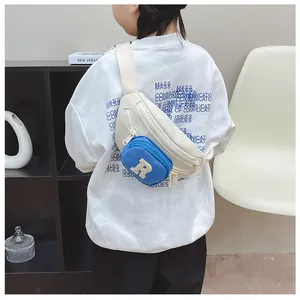 Detail of kids casual crossbody bag with white nylon strap and blue R-letter patch