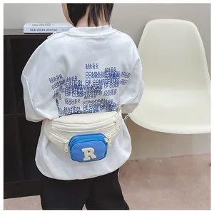 Rear view of a child wearing a beige and blue canvas belt bag with an R letter patch