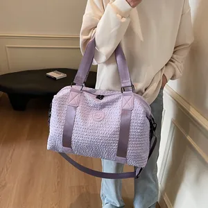 Detail of purple large capacity travel bag with crinkle texture and adjustable strap