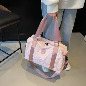 Detailed macro view of the water-ripple textured fabric and handles on a pink travel bag