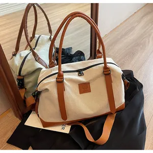Detail of the large canvas tote bag showing reinforced leather handles and zipper closure