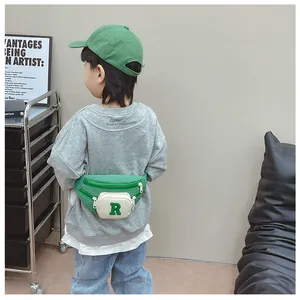 Close-up of kids green canvas waist bag featuring a white pocket with letter R patch