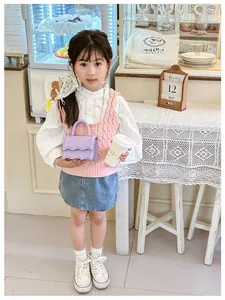 Détail du mini sac lilas avec motifs ondulés, poignée et bandoulière en chaîne métal