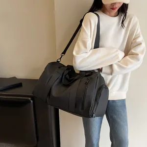 Detail of black sports travel bag featuring independent shoe compartment and shoulder strap
