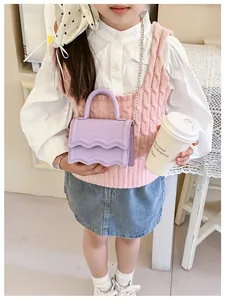 Fille portant un sac bandoulière lilas avec motif vagues et lettres dorées