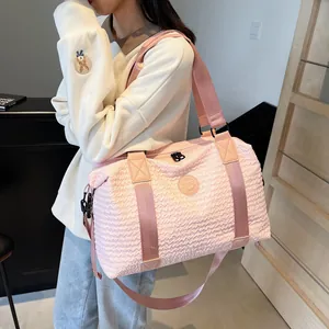 Detail of pink travel bag with bubble wave texture and adjustable shoulder strap