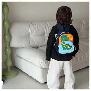 Dettaglio dello zaino dinosauro blu e arancione per bambini con tasca laterale in rete