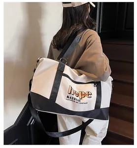 Detail view of large capacity travel bag with double handles and adjustable shoulder strap