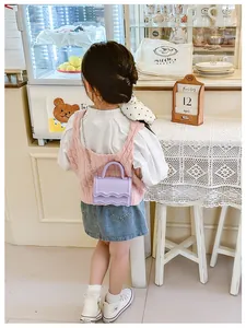 Détail du mini sac bandoulière violet avec volants ondulés et chaîne argentée